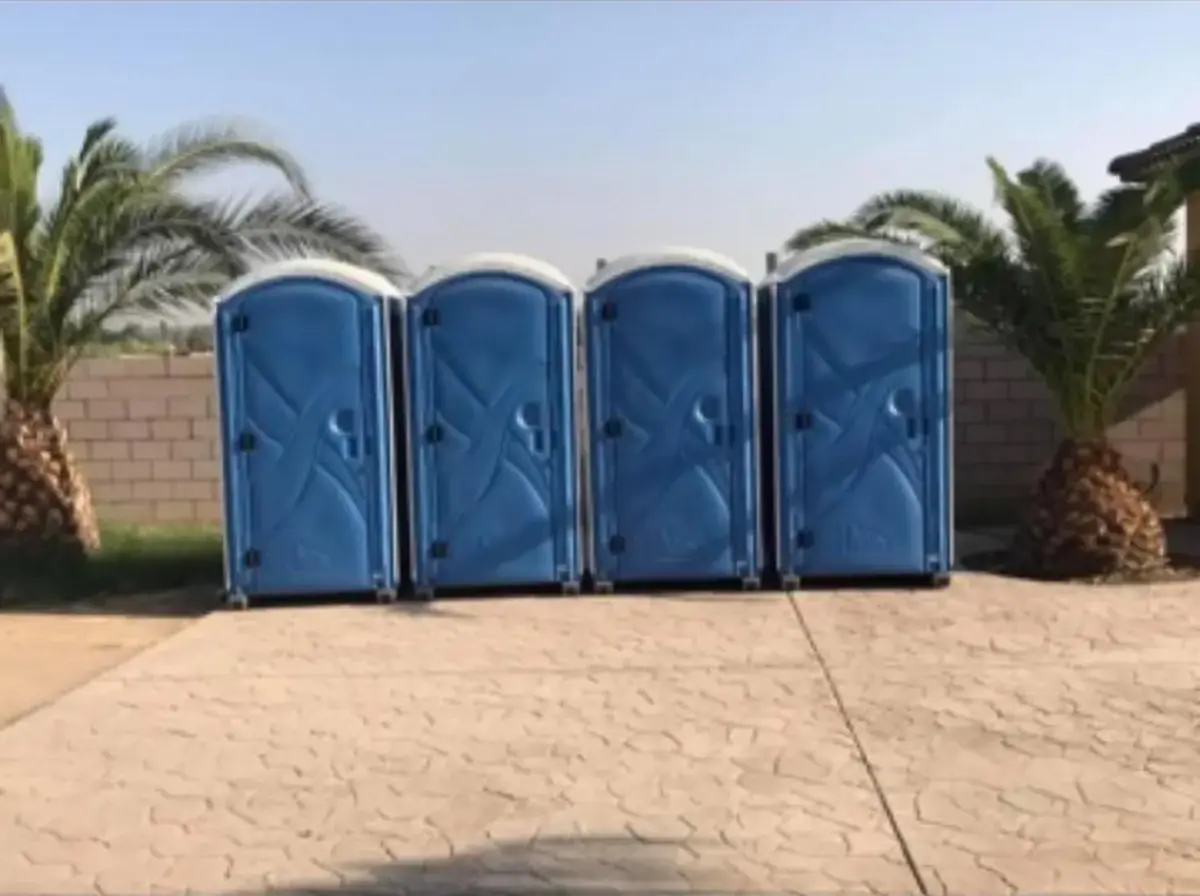 Bank of four standard porta potties like those we deliver across Summit County